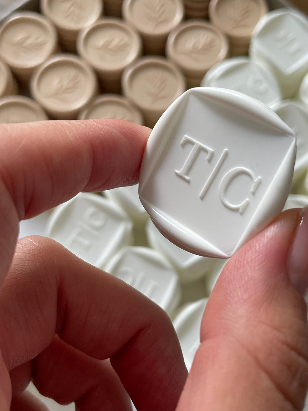 White custom wax seal with embossed initials for wedding envelope sealing