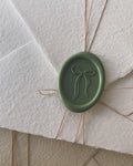 Green handmade wax seal with bow design for wedding invitations