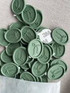 Green wax seals with bow design for wedding invitations